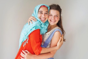 Two young women smiling and hugging